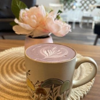 Hot ube latte with leaf latte art in a ceramic mug