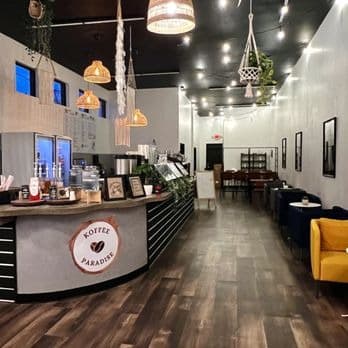 Inside Koffee Paradise with the logo counter, rattan pendant lights and seating