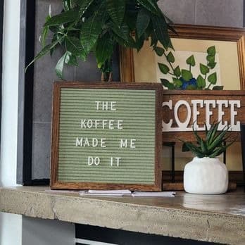 Letter board reading The Koffee Made Me Do It next to plants