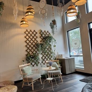 Seating corner at Koffee Paradise with plant trellis, hanging plants and woven lamps
